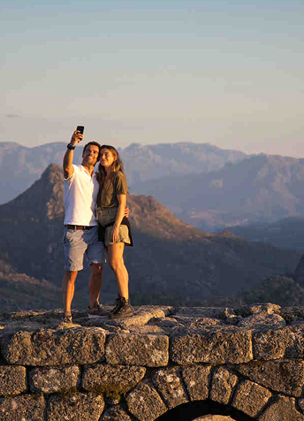 Couple taking a selfie atop a stone wall in Peneda-Gerês National Park